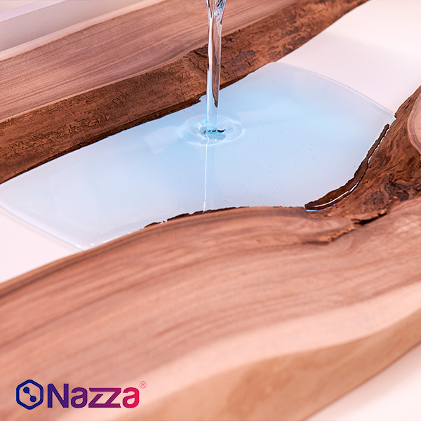 Vertido de resina epoxi transparente de alto grosor en el hueco central de dos piezas de madera natural, típico en la fabricación de mesas tipo “río”. La resina fluye suavemente formando una superficie lisa y cristalina, resaltando el contraste entre la calidez de la madera y la pureza del acabado. La escena transmite precisión y cuidado en el proceso, ideal para mostrar la aplicación correcta en proyectos decorativos y de carpintería de alto valor estético.