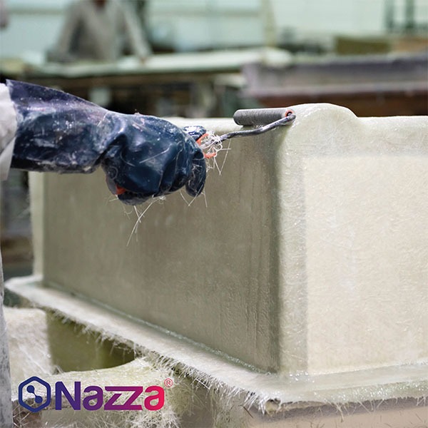 persona trabajando en la fabricación de una pieza utilizando fibra de vidrio y resina de poliéster. La persona está usando un guante de protección y aplicando la resina con un rodillo en la superficie de la pieza. El entorno parece ser un taller, con una estructura que aún está en proceso de fabricación, visible en el fondo. La fibra de vidrio sobresale alrededor de la pieza, evidenciando el proceso de laminado para crear una pieza resistente. El logo de Nazza aparece en la parte inferior izquierda, indicando la marca asociada al proceso.