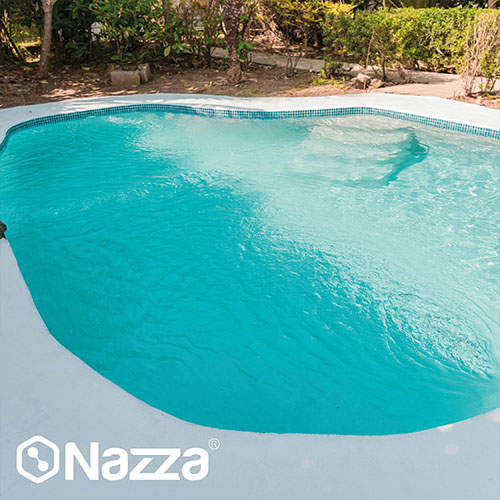 Piscina de poliéster con formas irregulares, restaurada con un revestimiento uniforme y un contorno limpio, lista para disfrutar en un entorno natural y bien integrado.
