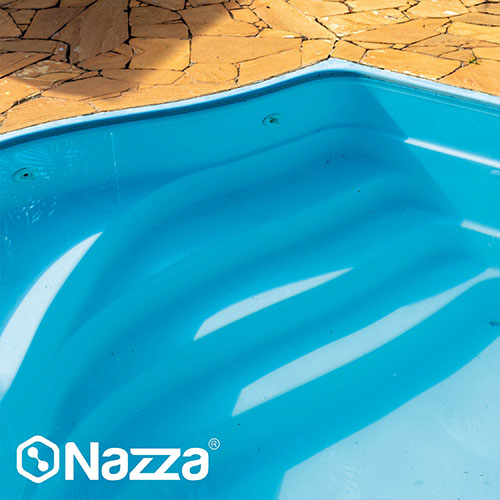 Escalera de piscina de poliéster completamente reparada, con un acabado azul intenso, liso y brillante que refleja la luz, muestra una restauración profesional y lista para llenar.