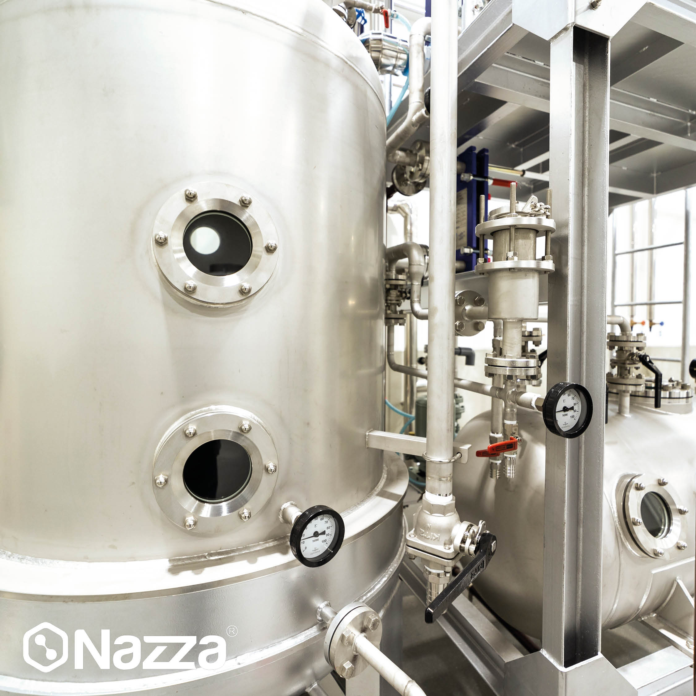 ChatGPT Plus La imagen muestra un gran depósito industrial de acero inoxidable con varias válvulas, manómetros y conexiones de tuberías. Se observan mirillas circulares en la superficie del tanque y una estructura metálica que sostiene la instalación, típica de sistemas de almacenamiento o procesamiento de líquidos como agua o productos alimentarios en entornos higiénicos
